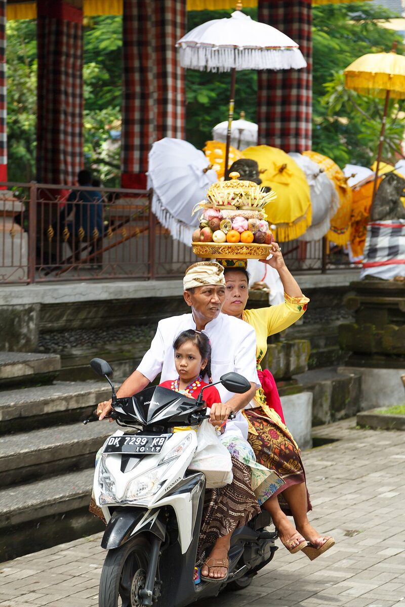 Warga Ubud membawa sesajen ke Pura Dalem Puri dengan motor