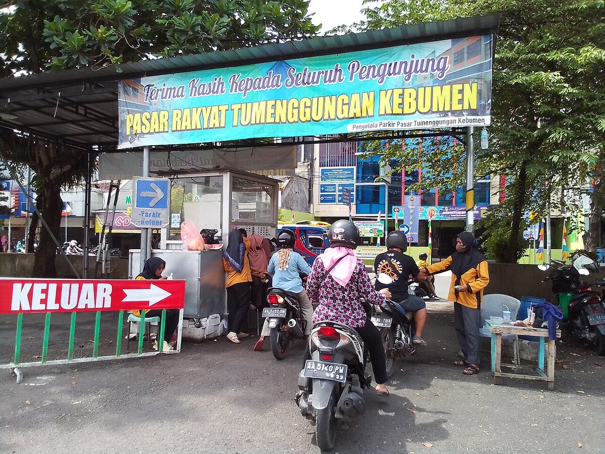 Area parkir sepeda motor dengan petugas di pintu keluar pasar