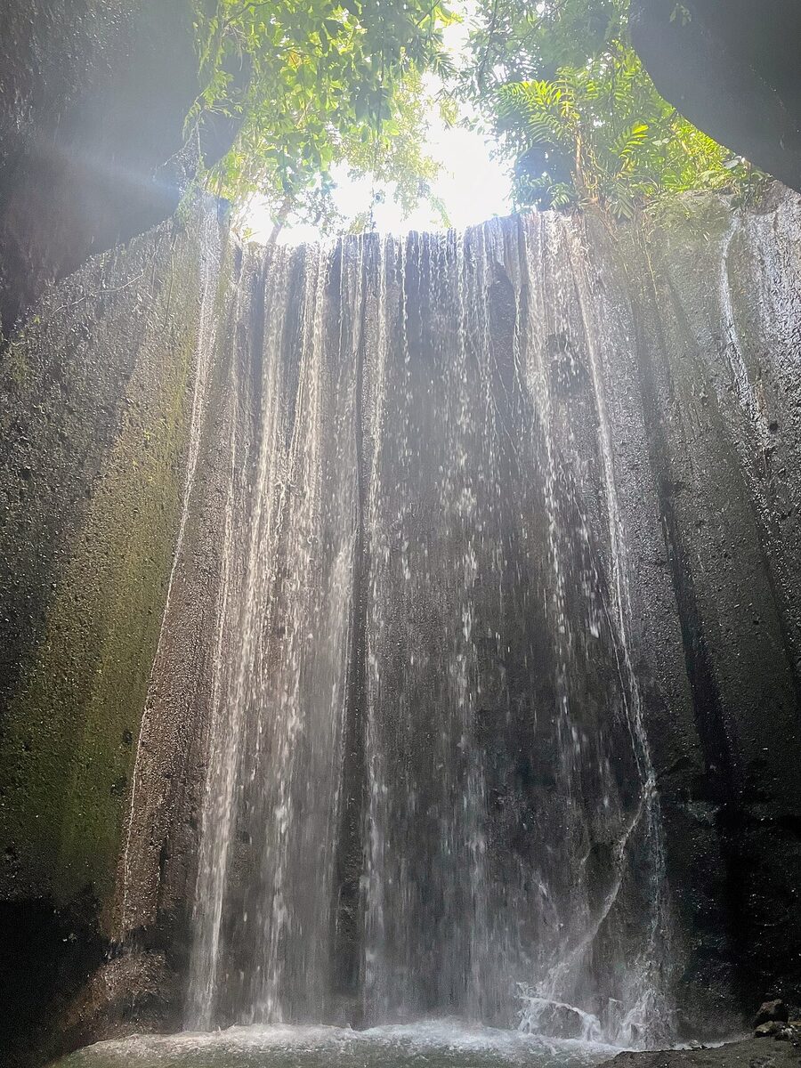 Tukad Cepung Waterfall in Tembuku District, Bangli, falling inside a rock-cliff crevice.