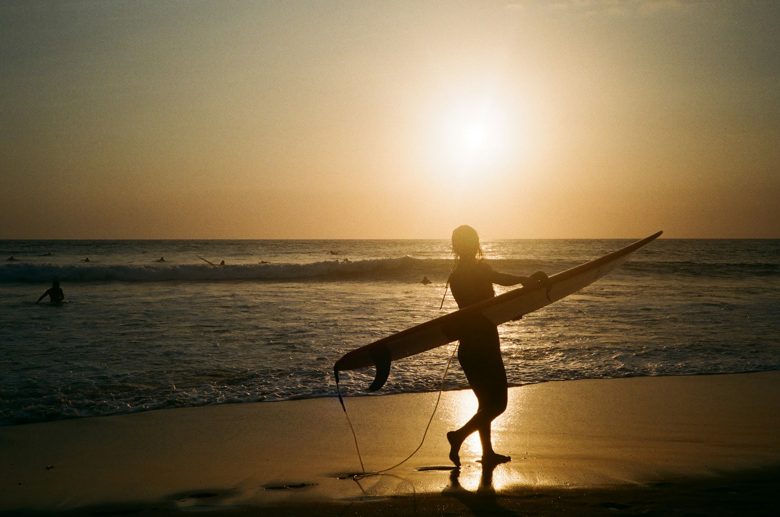 Surfer on Canggu beach at sunset